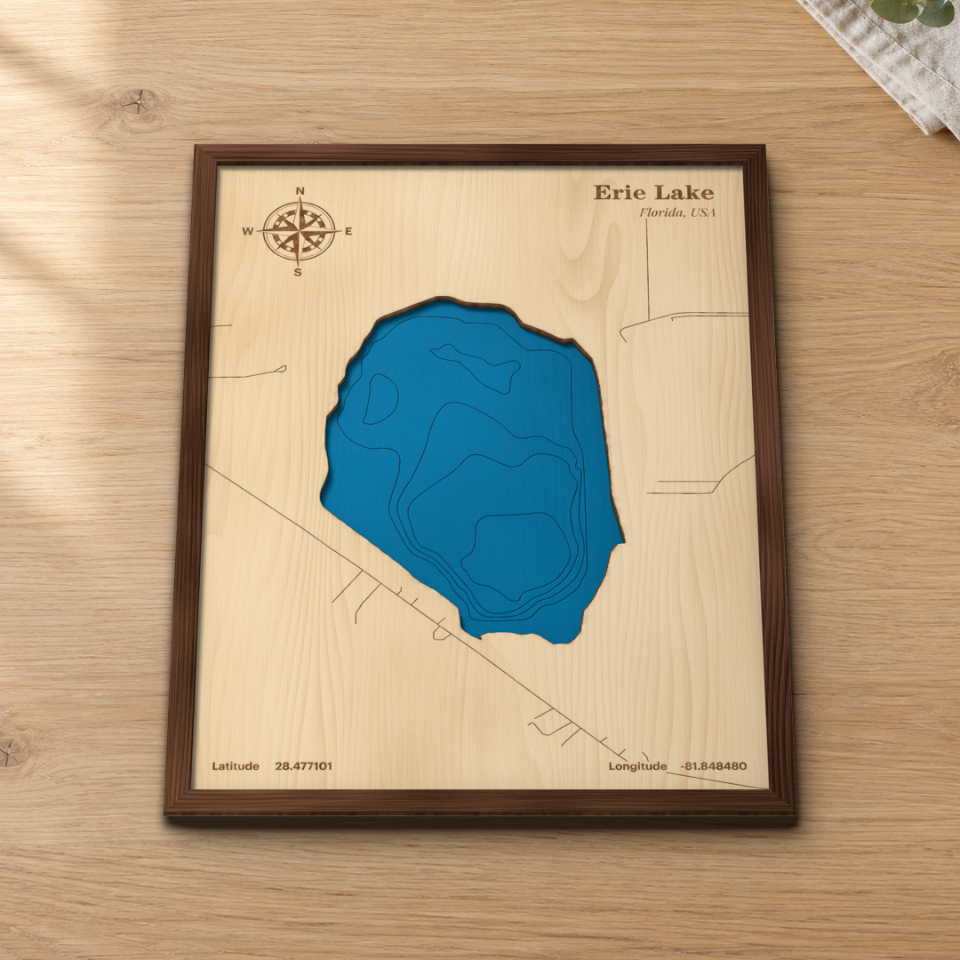 Erie Lake wood map lying flat on a wooden tabletop, showing the lake's depth contours and nearby roads