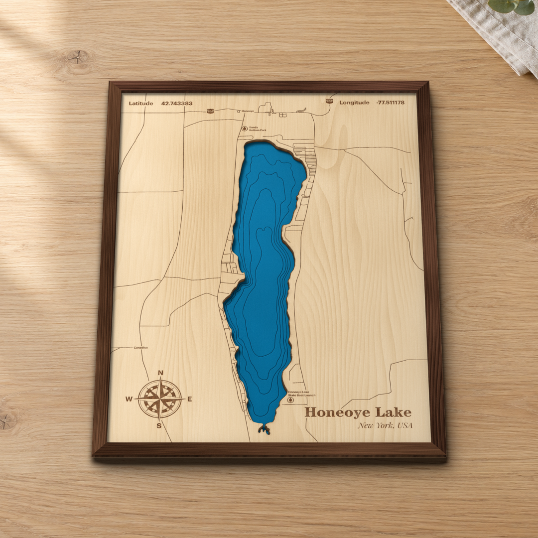 Honeoye Lake wood map lying flat on a wooden tabletop, showing the lake's depth contours with Honeoye, Sandy Bottom Park and the State Boat Launch engraved in