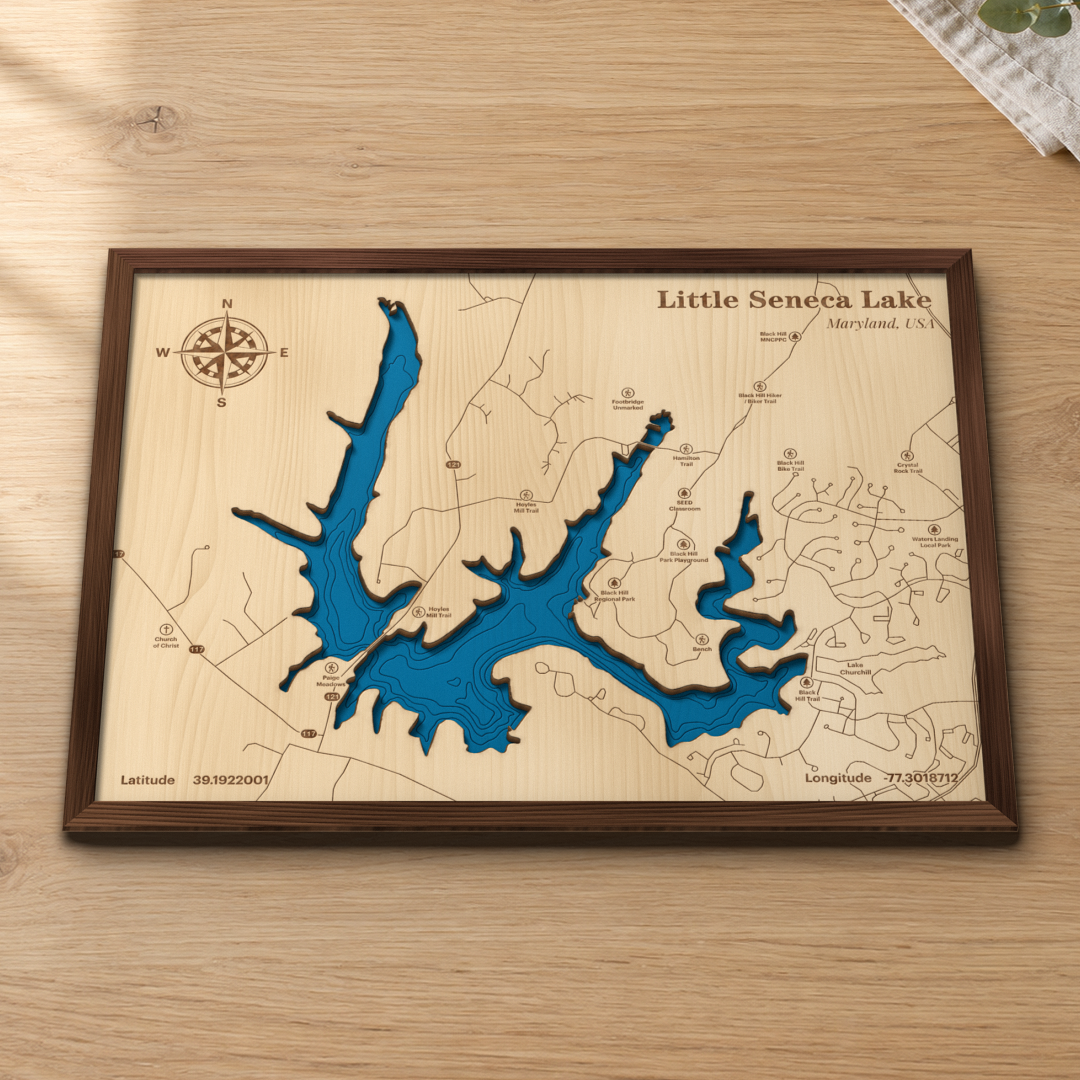 Little Seneca Lake wood map lying flat on a wooden tabletop, showing the reservoir's depth contours with engraved trails and Black Hill Regional Park