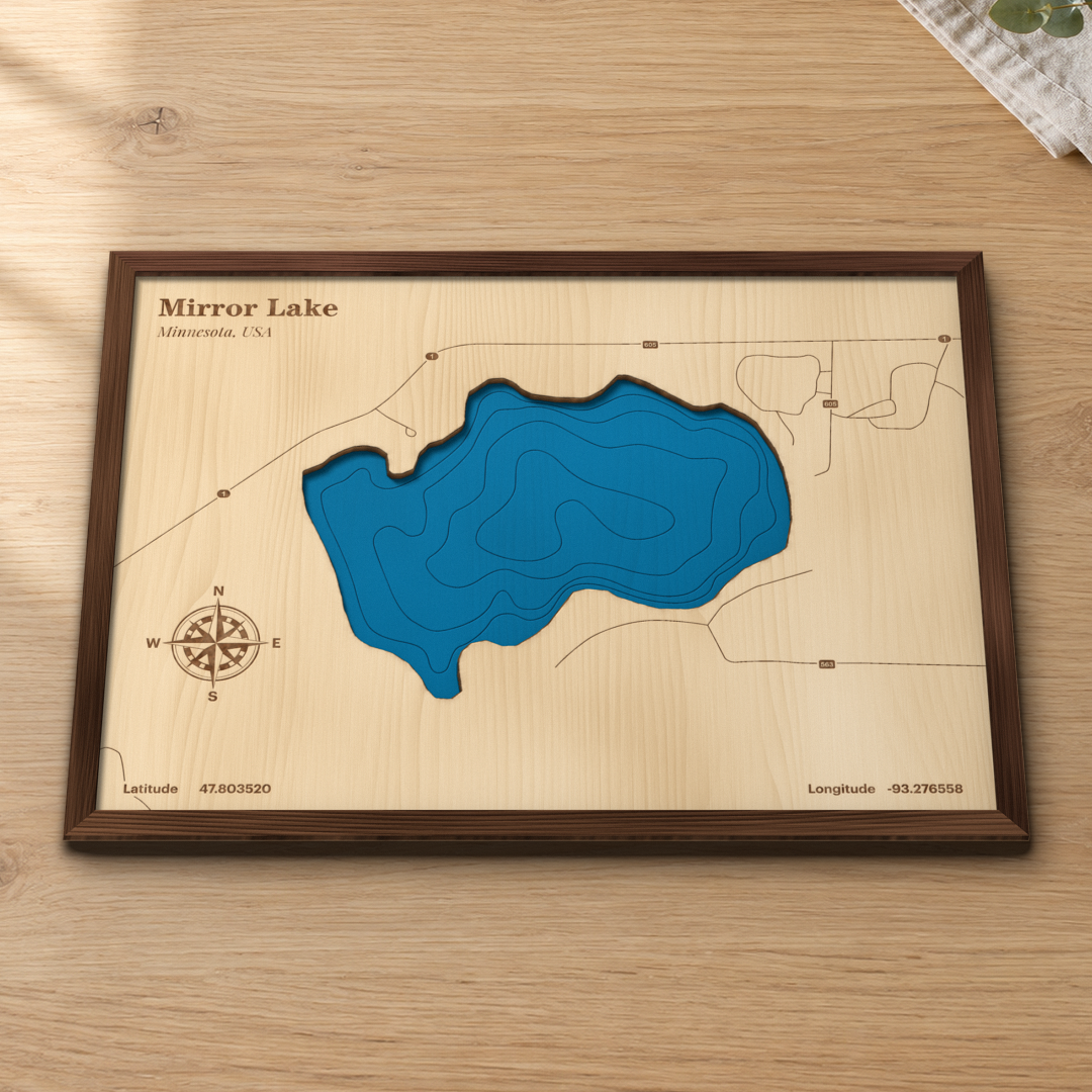Mirror Lake wood map lying flat on a wooden tabletop, showing the lake's depth contours and Highway 1