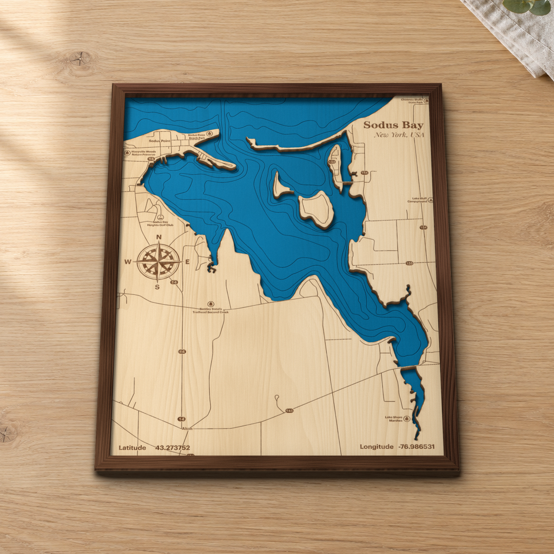 Sodus Bay wood map lying flat on a wooden tabletop, showing Sodus Point, the bay islands and depth contours