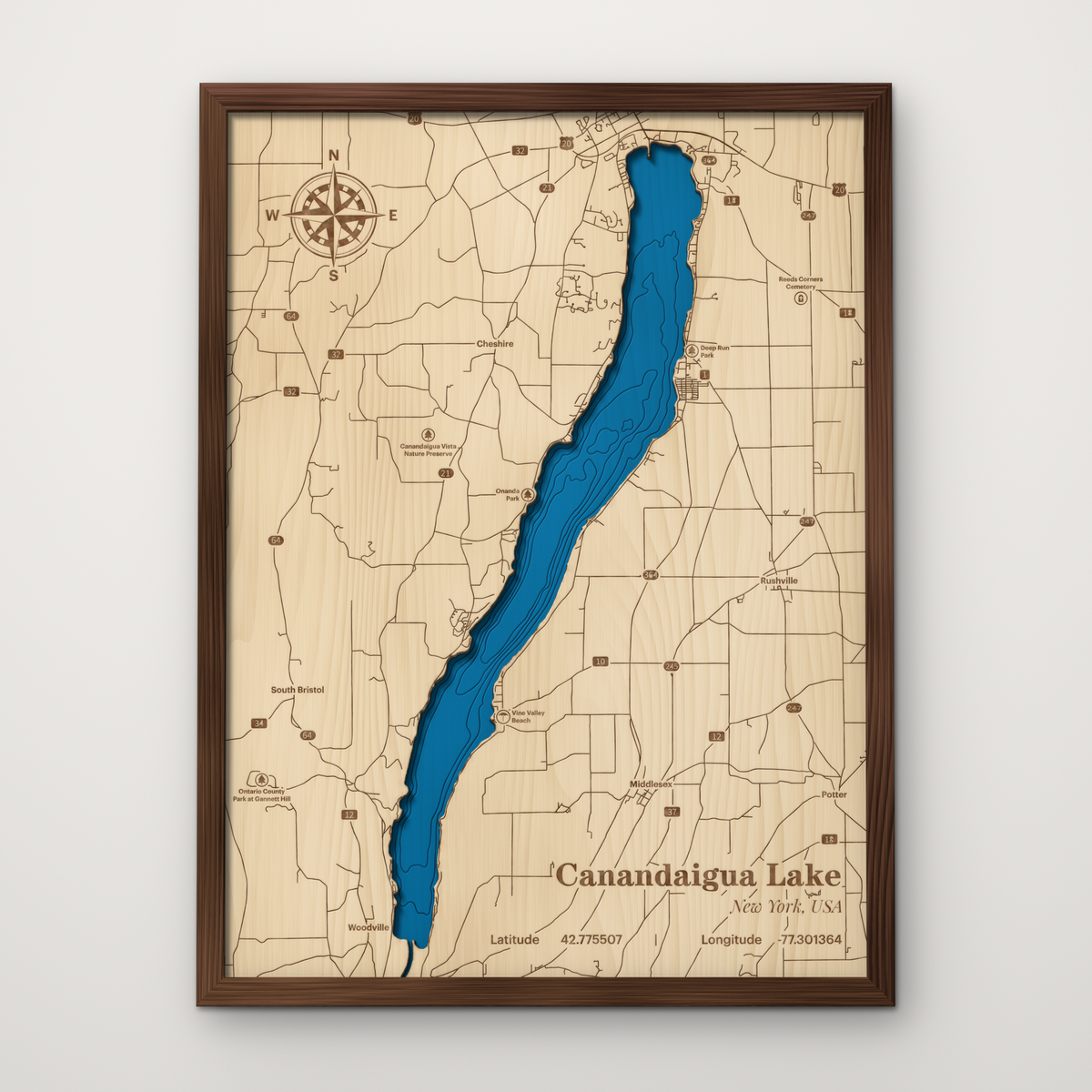 Canandaigua Lake layered wood map in a stained walnut frame, with hand-painted blue water and surrounding roads and towns engraved in maple