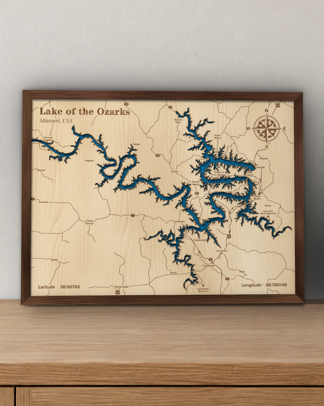 Lake of the Ozarks wood map in a stained walnut frame leaning on a wooden sideboard in a living room