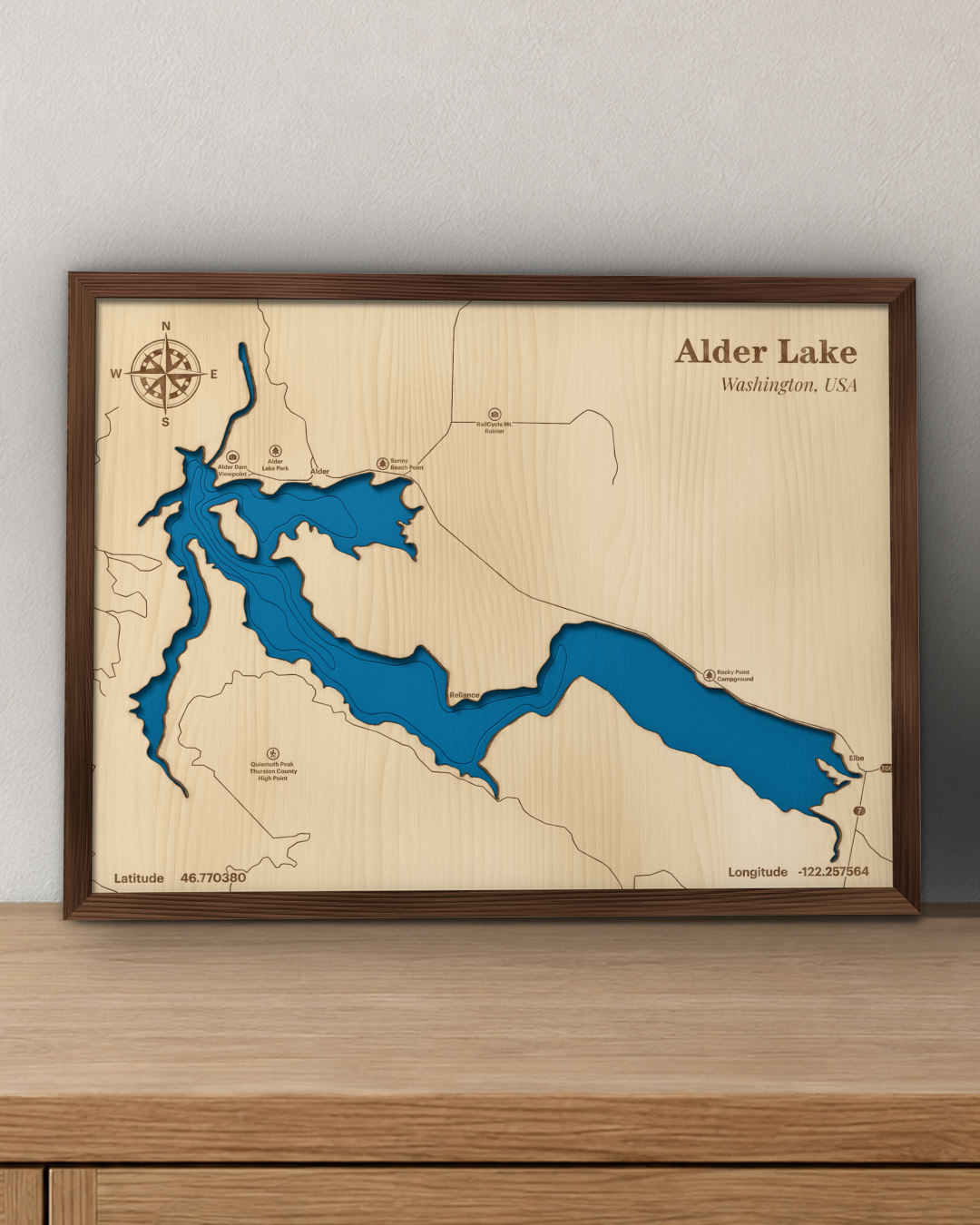 Alder Lake wood map in a walnut frame standing on a wooden sideboard against a wall for scale