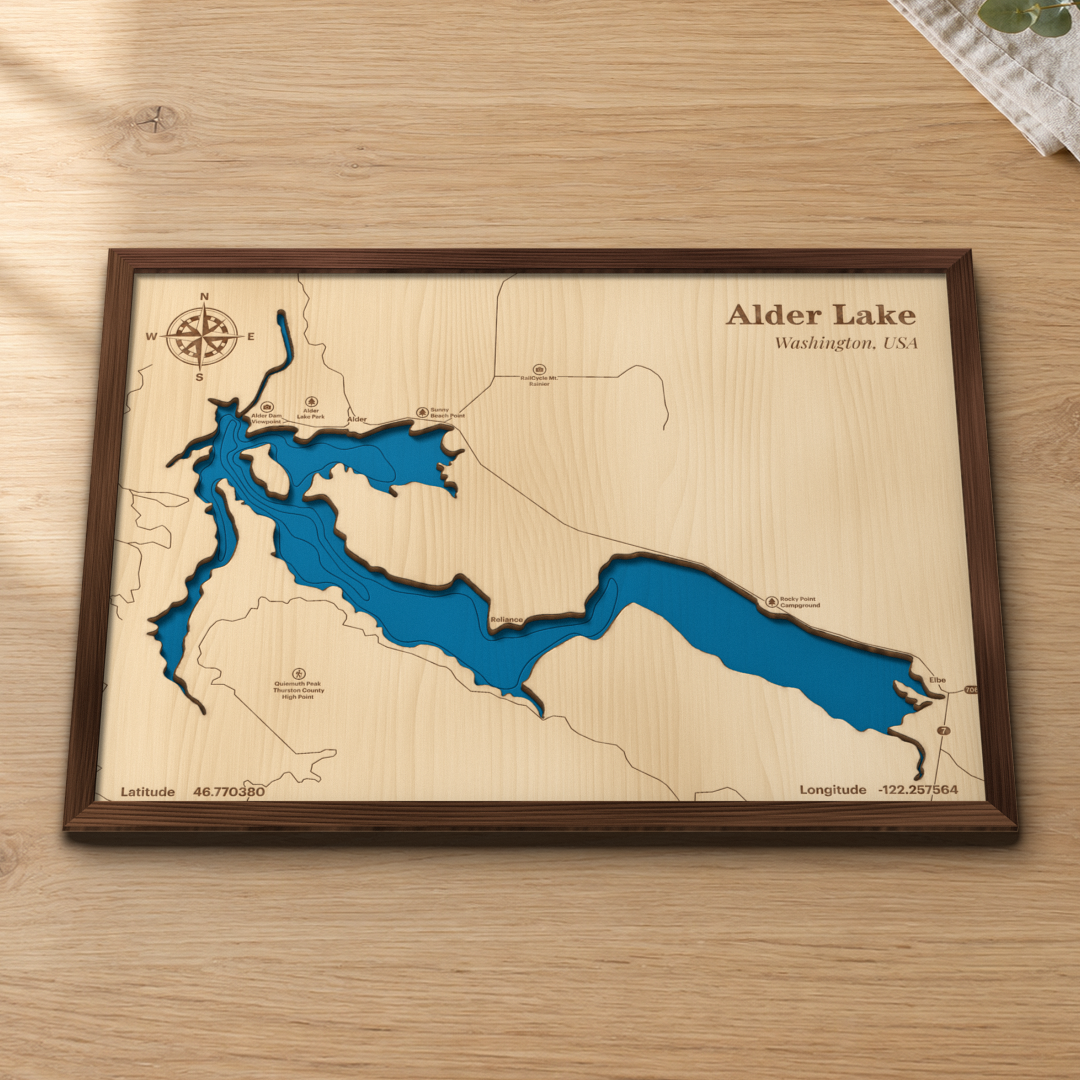 Alder Lake wood map lying flat on a wooden tabletop, showing the reservoir's depth contours with Alder, Elbe, Alder Lake Park and the routes around the shore engraved in