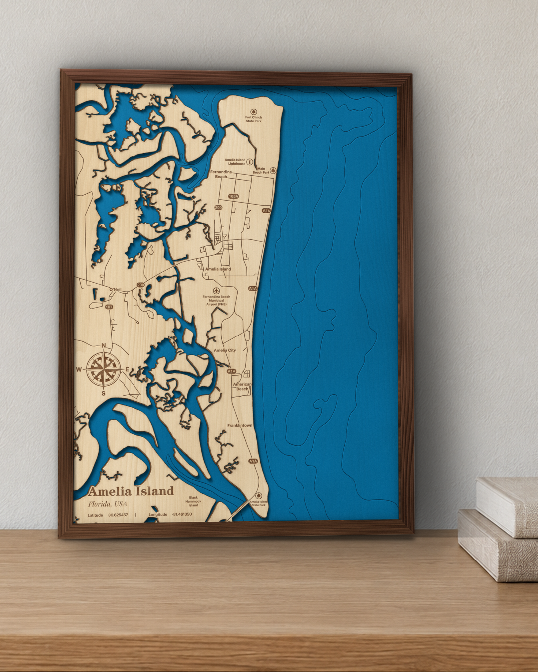 Amelia Island wood map in a walnut frame standing on a wooden sideboard against a wall for scale