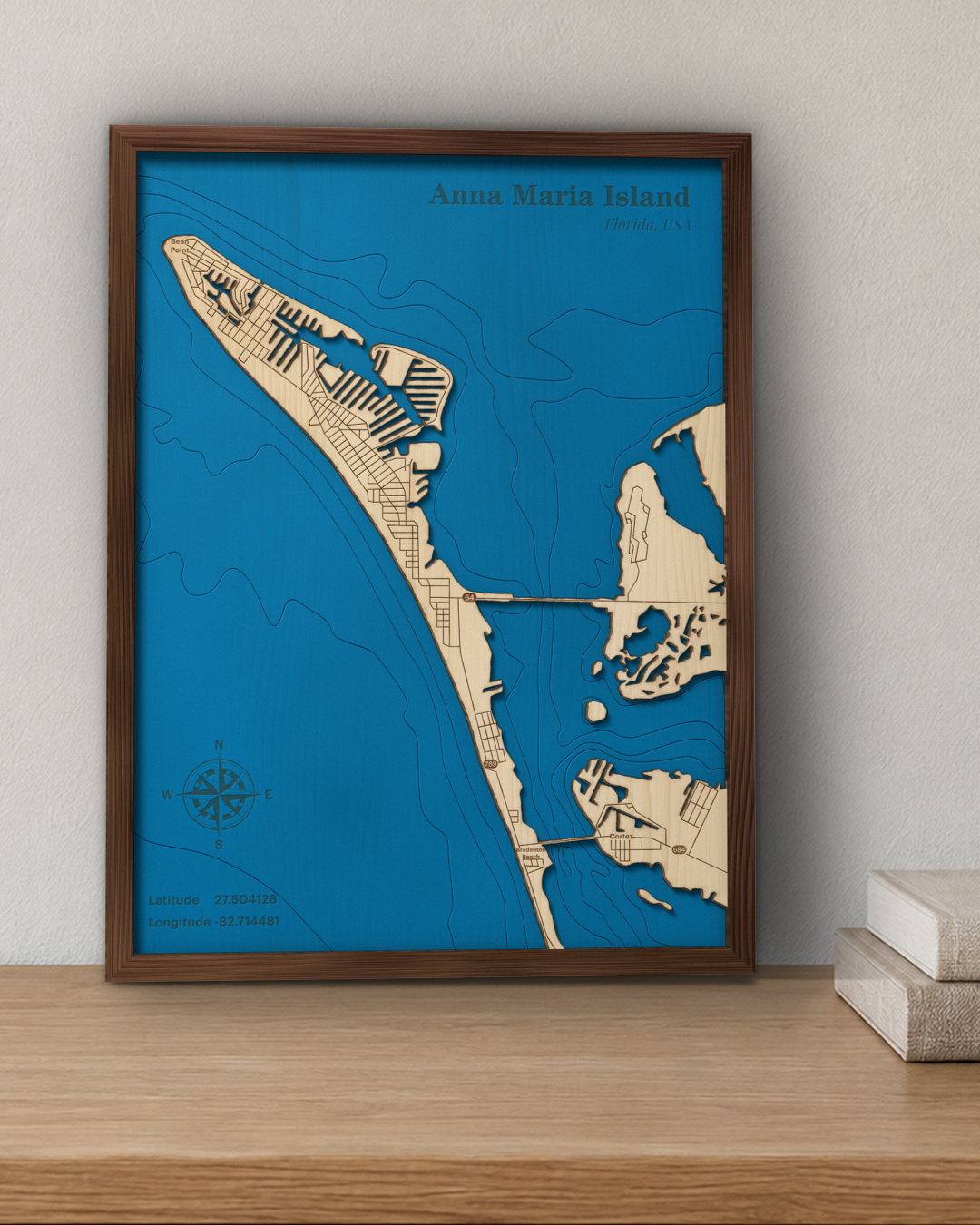 Anna Maria Island wood map in a walnut frame standing on a wooden sideboard against a wall for scale
