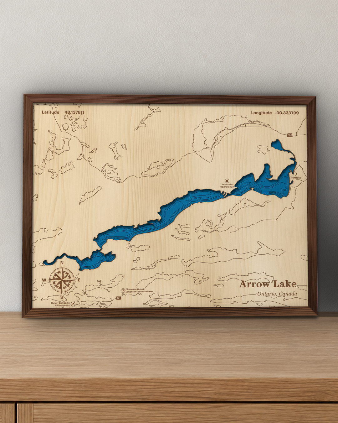 Arrow Lake wood map in a walnut frame standing on a wooden sideboard against a wall for scale