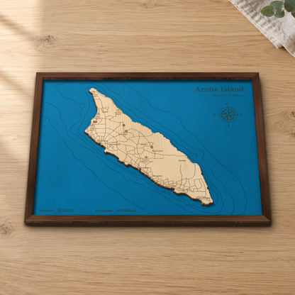 Aruba wood map lying flat on a wooden tabletop, showing the whole island and its offshore depth contours, with engraved towns, beaches and roads from Oranjestad to San Nicolas