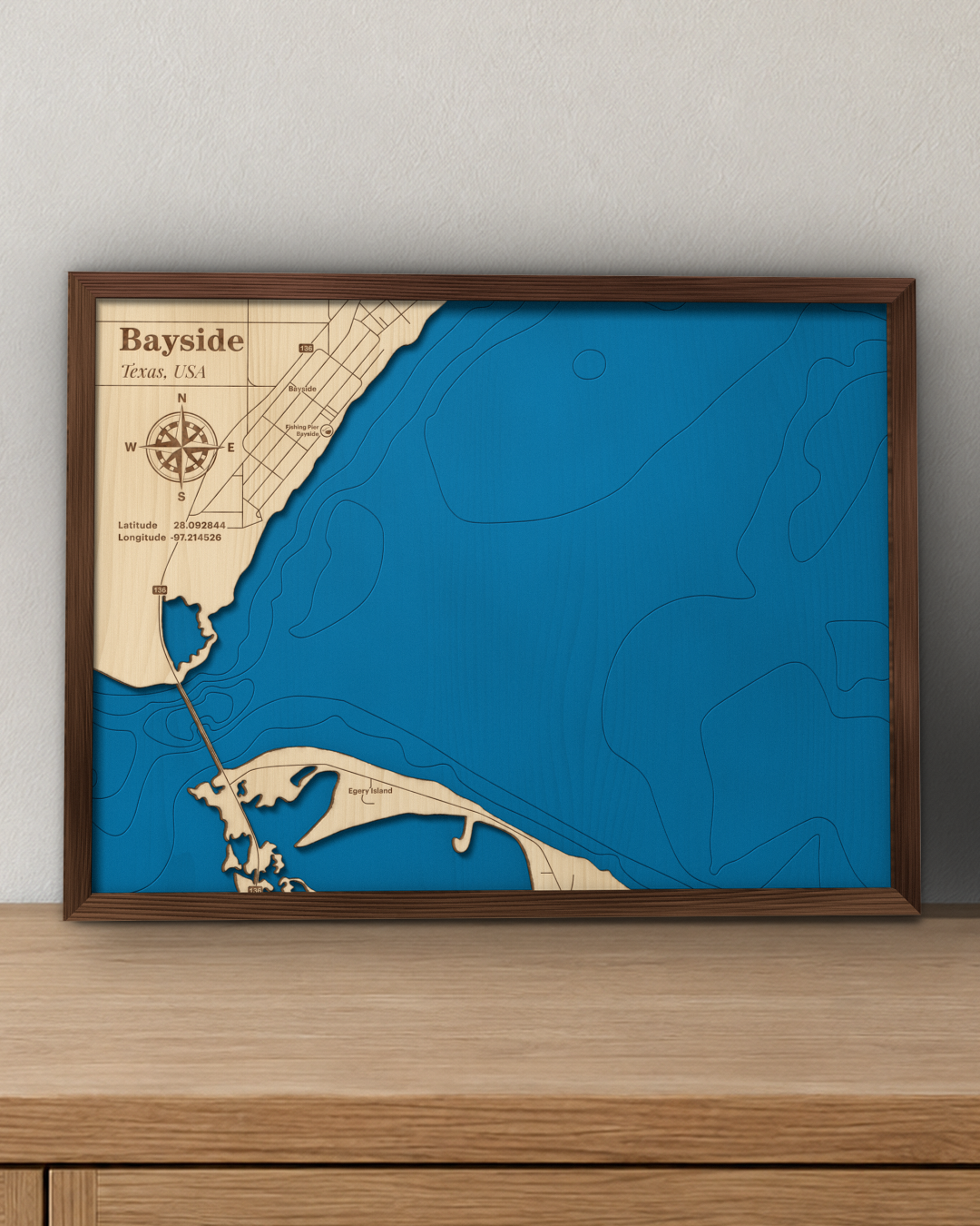 Bayside wood map in a walnut frame standing on a wooden sideboard against a wall for scale