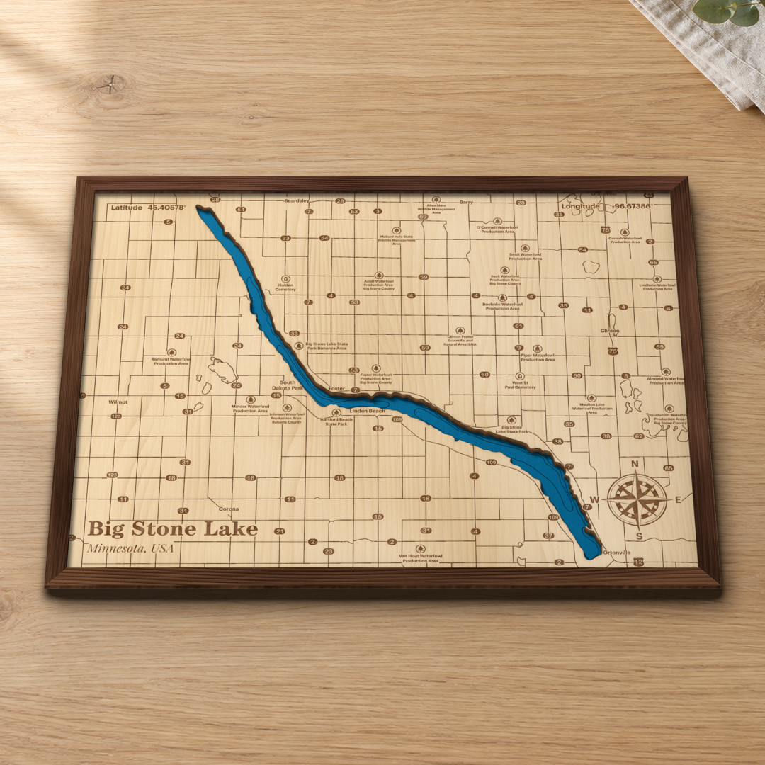 Big Stone Lake wood map lying flat on a wooden tabletop, showing the lake's depth contours with Ortonville, the state parks and the waterfowl production areas engraved in