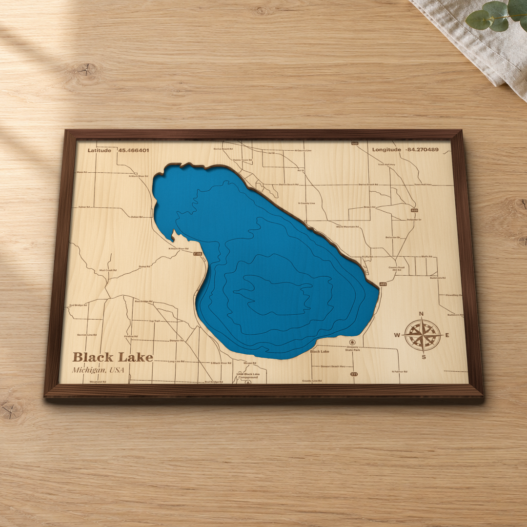 Black Lake wood map lying flat on a wooden tabletop, showing the whole lake's depth contours, with engraved roads, Onaway State Park and the UAW Black Lake Campground