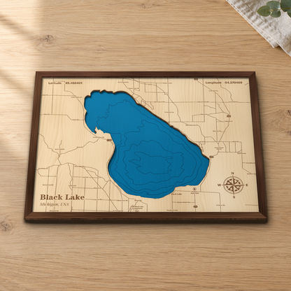 Black Lake wood map lying flat on a wooden tabletop, showing the whole lake's depth contours, with engraved roads, Onaway State Park and the UAW Black Lake Campground