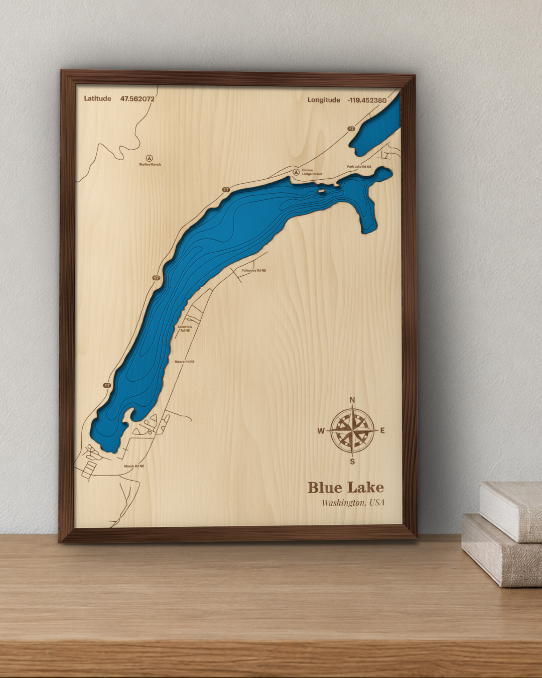 Blue Lake wood map in a walnut frame standing on a wooden sideboard against a wall for scale