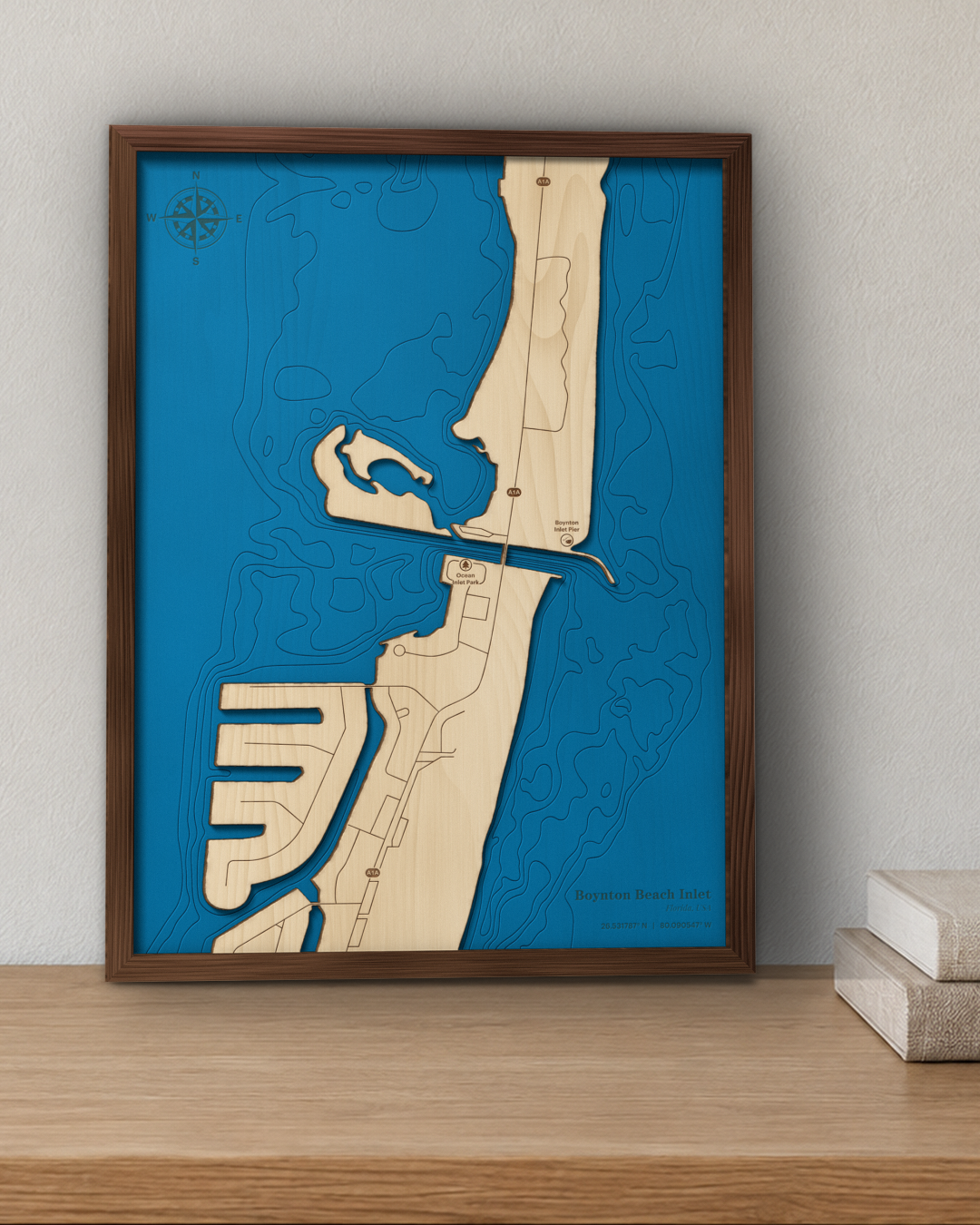 Boynton Beach Inlet wood map in a walnut frame standing on a wooden sideboard against a wall for scale