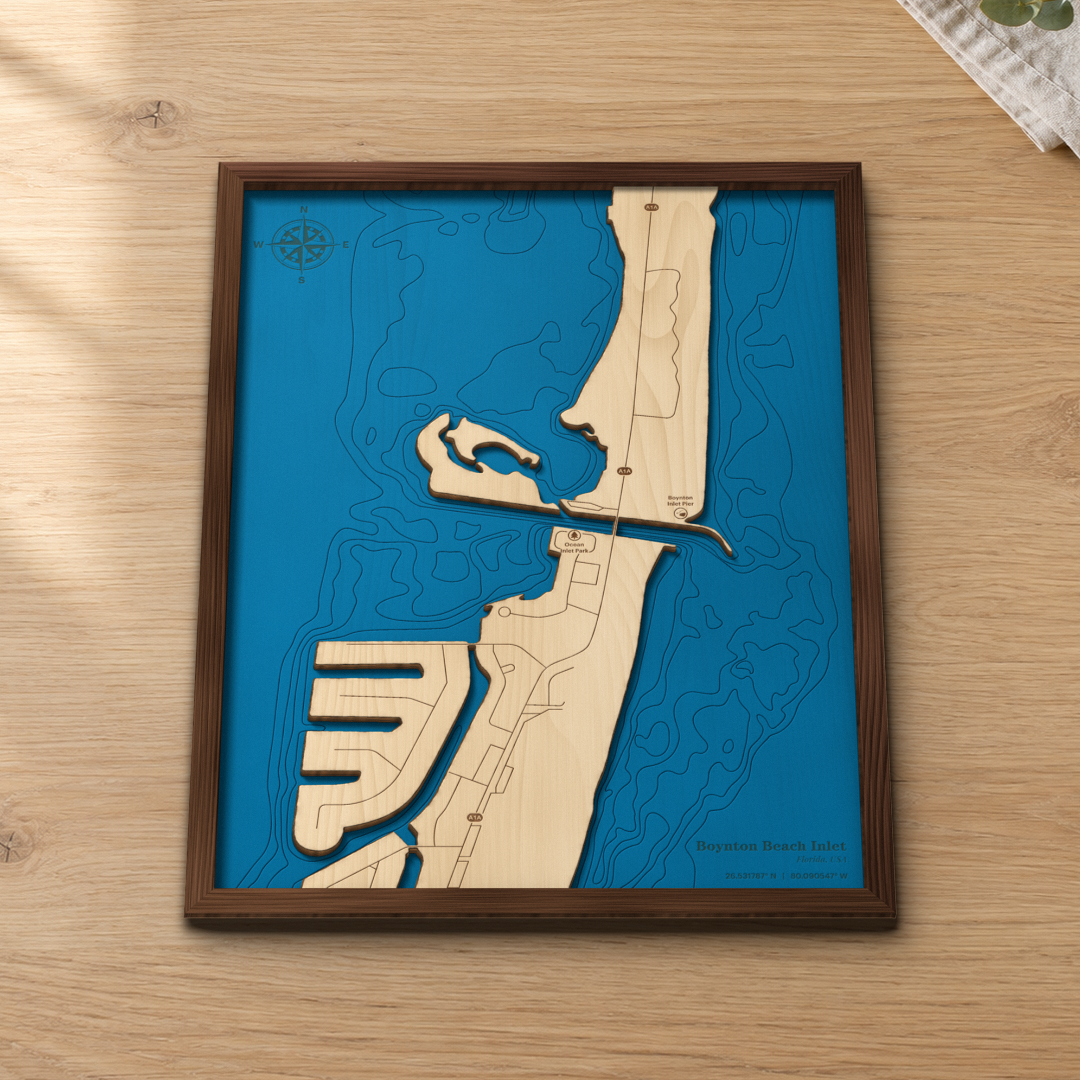 Boynton Beach Inlet wood map lying flat on a wooden tabletop, showing the ocean and Intracoastal depth contours and the inlet engraved in