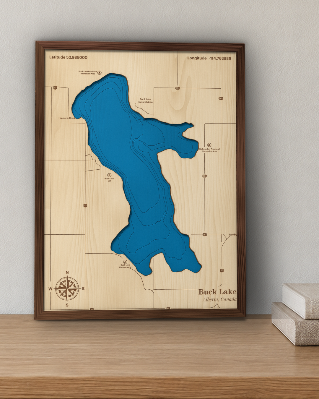 Buck Lake wood map in a walnut frame standing on a wooden sideboard against a wall for scale