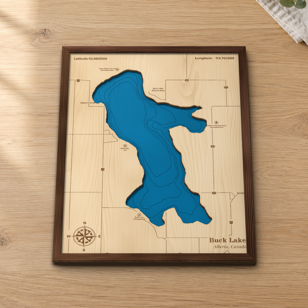 Buck Lake wood map lying flat on a wooden tabletop, showing the depth contours and the bays engraved in