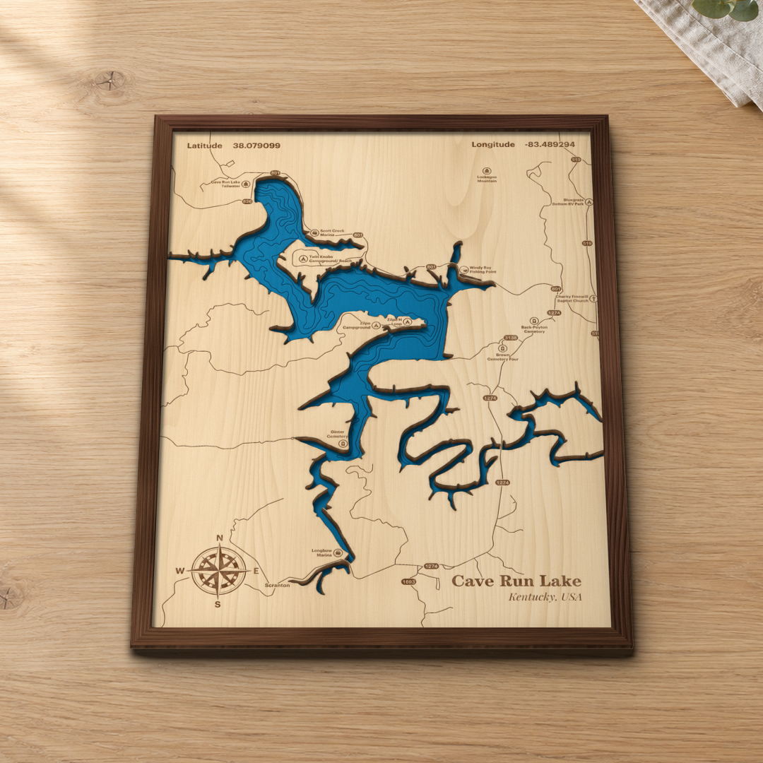 Cave Run Lake wood map lying flat on a wooden tabletop, showing the depth contours and the winding arms of the lake engraved in