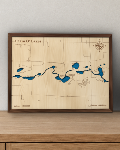 Chain O' Lakes wood map in a walnut frame standing on a wooden sideboard against a wall for scale