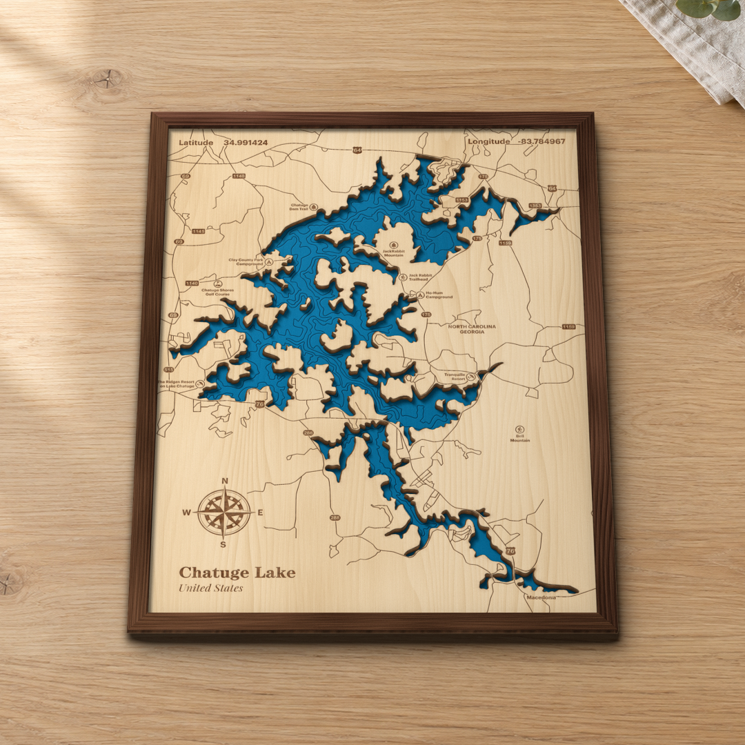 Chatuge Lake wood map lying flat on a wooden tabletop, showing the depth contours of the main lake and its coves engraved in