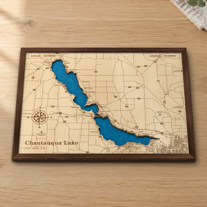 Chautauqua Lake wood map lying flat on a wooden tabletop, showing both basins' depth contours split at Bemus Point, with engraved towns and highways from Mayville to Jamestown