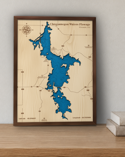 Chequamegon Waters Flowage wood map in a walnut frame standing on a wooden sideboard against a wall for scale