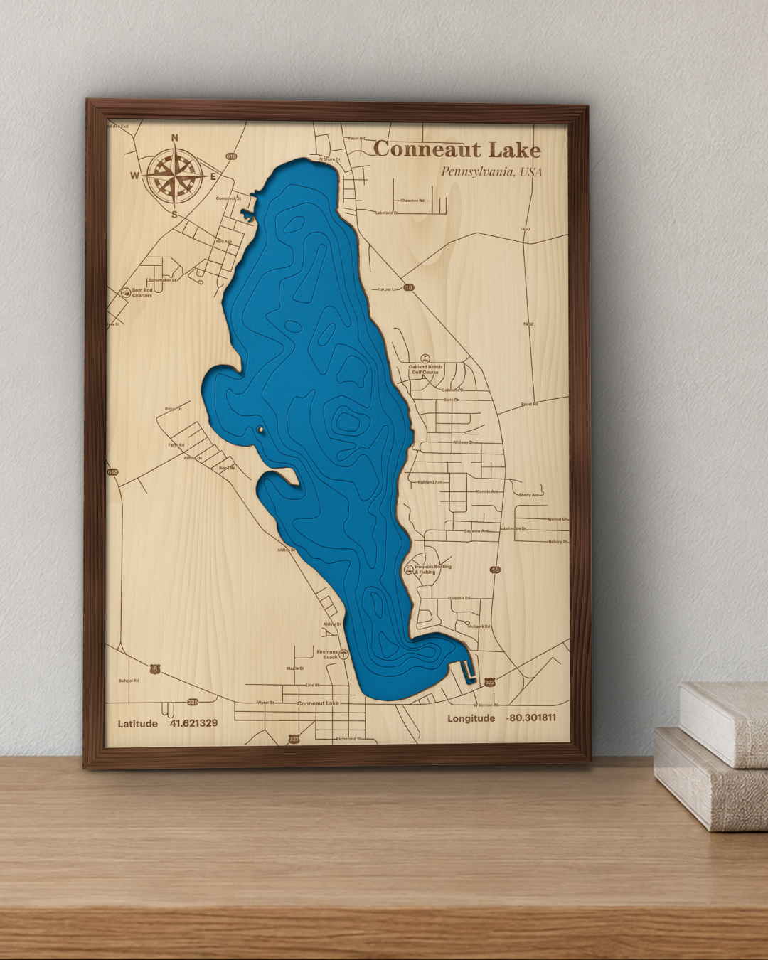 Conneaut Lake wood map in a walnut frame standing on a wooden sideboard against a wall for scale