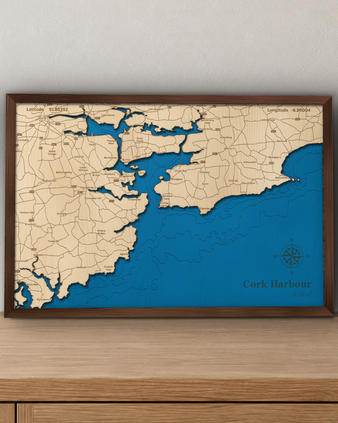 Cork Harbour wood map in a walnut frame standing on a wooden sideboard against a wall for scale