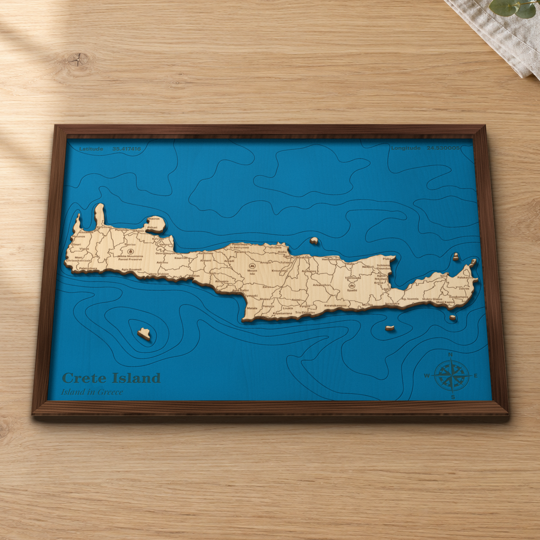 Crete wood map lying flat on a wooden tabletop, showing the Aegean and Libyan Sea depth contours engraved in