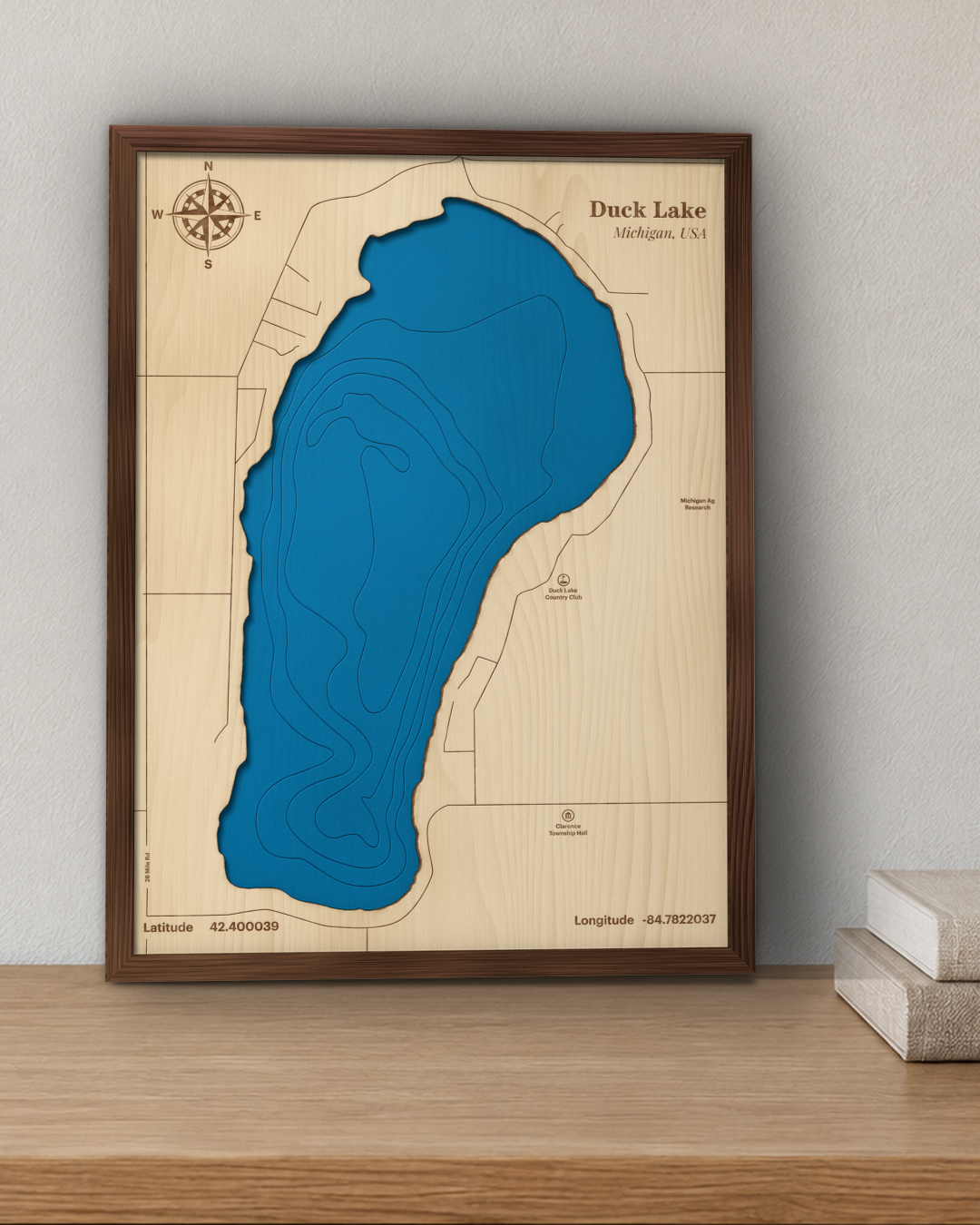 Duck Lake wood map in a walnut frame standing on a wooden sideboard against a wall for scale