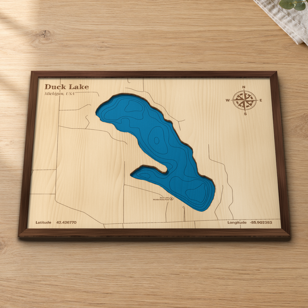 Duck Lake wood map lying flat on a wooden tabletop, showing the lake's basins and depth contours