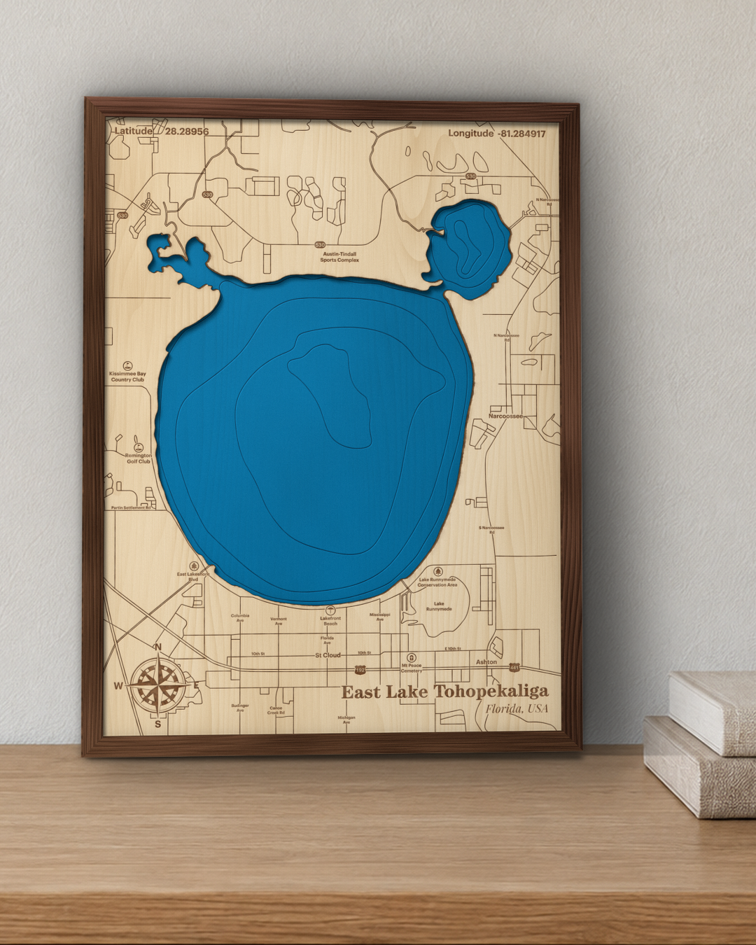 East Lake Tohopekaliga wood map in a walnut frame standing on a wooden sideboard against a wall for scale