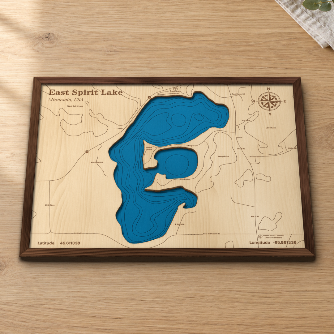 East Spirit Lake wood map lying flat on a wooden tabletop, showing the lake's bays and depth contours with Spirit Lake Resort and the surrounding lake roads engraved in