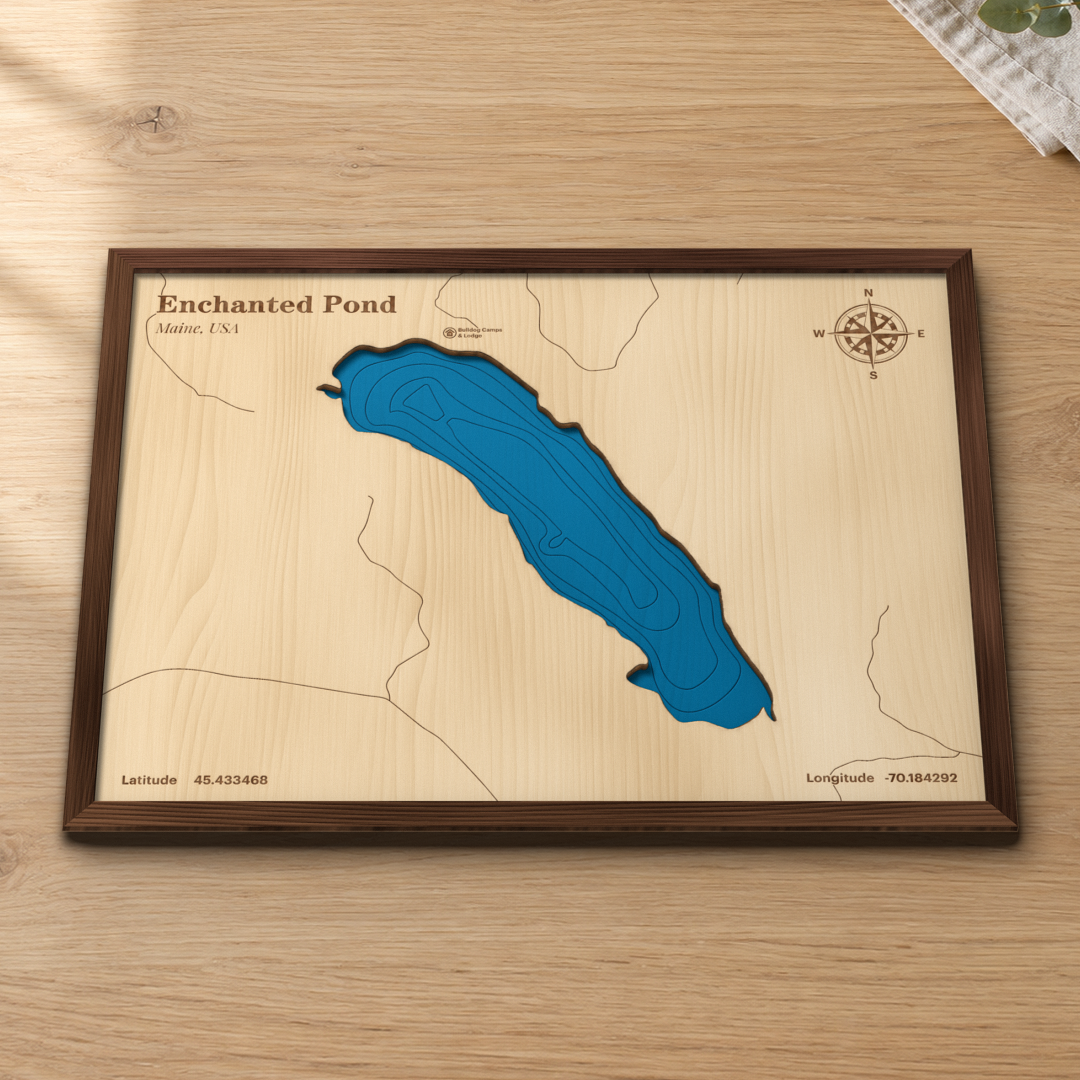 Enchanted Pond wood map lying flat on a wooden tabletop, showing the depth contours engraved in