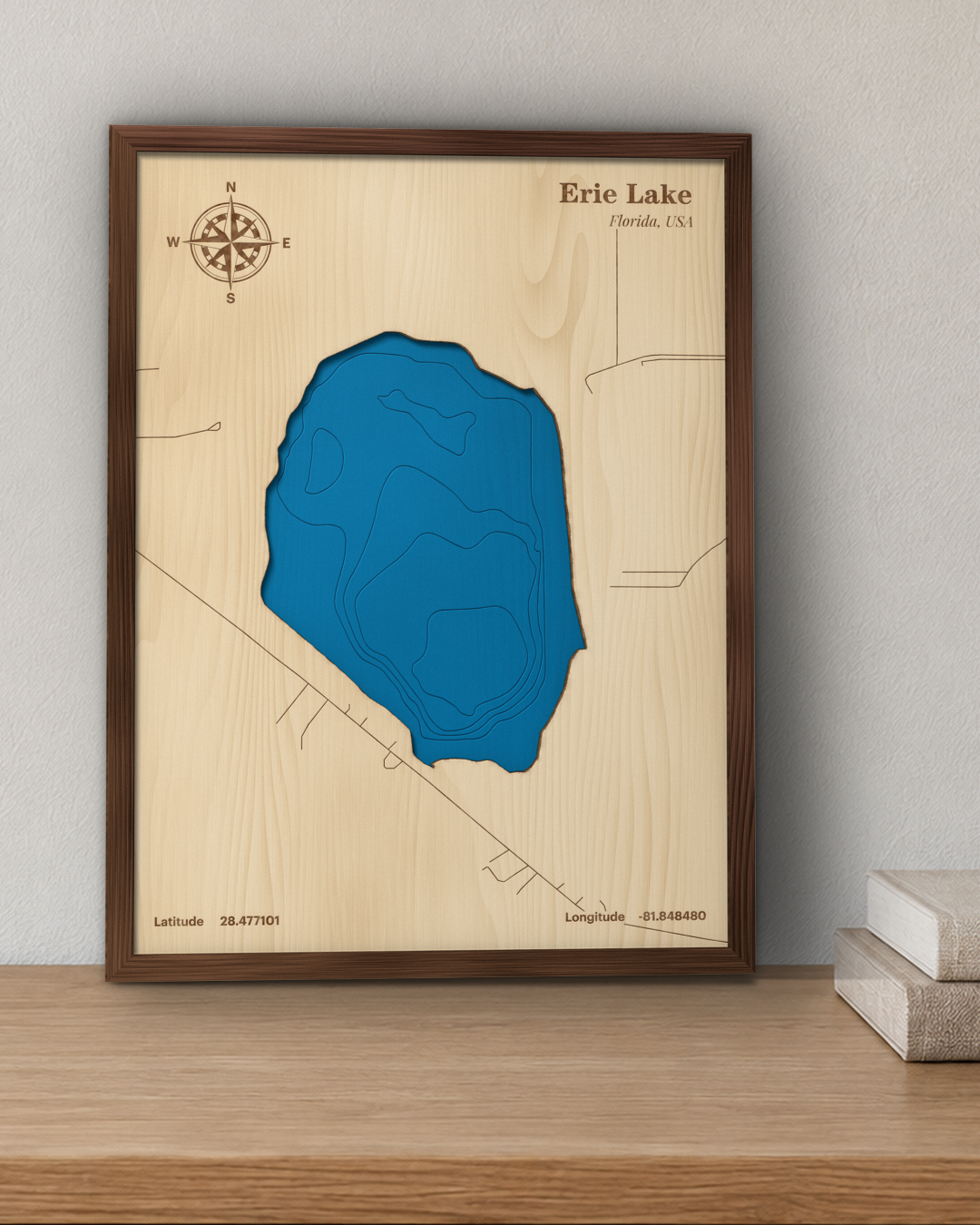 Erie Lake wood map in a walnut frame standing on a wooden sideboard against a wall for scale