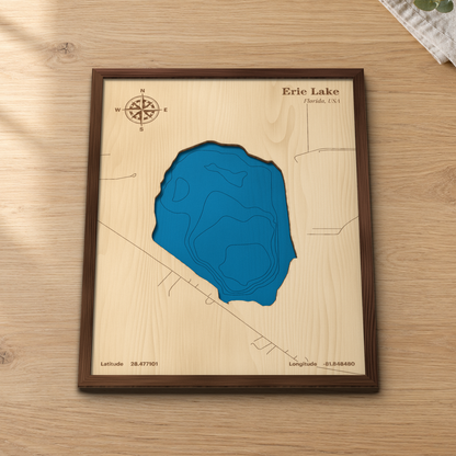 Erie Lake wood map lying flat on a wooden tabletop, showing the lake's depth contours and nearby roads