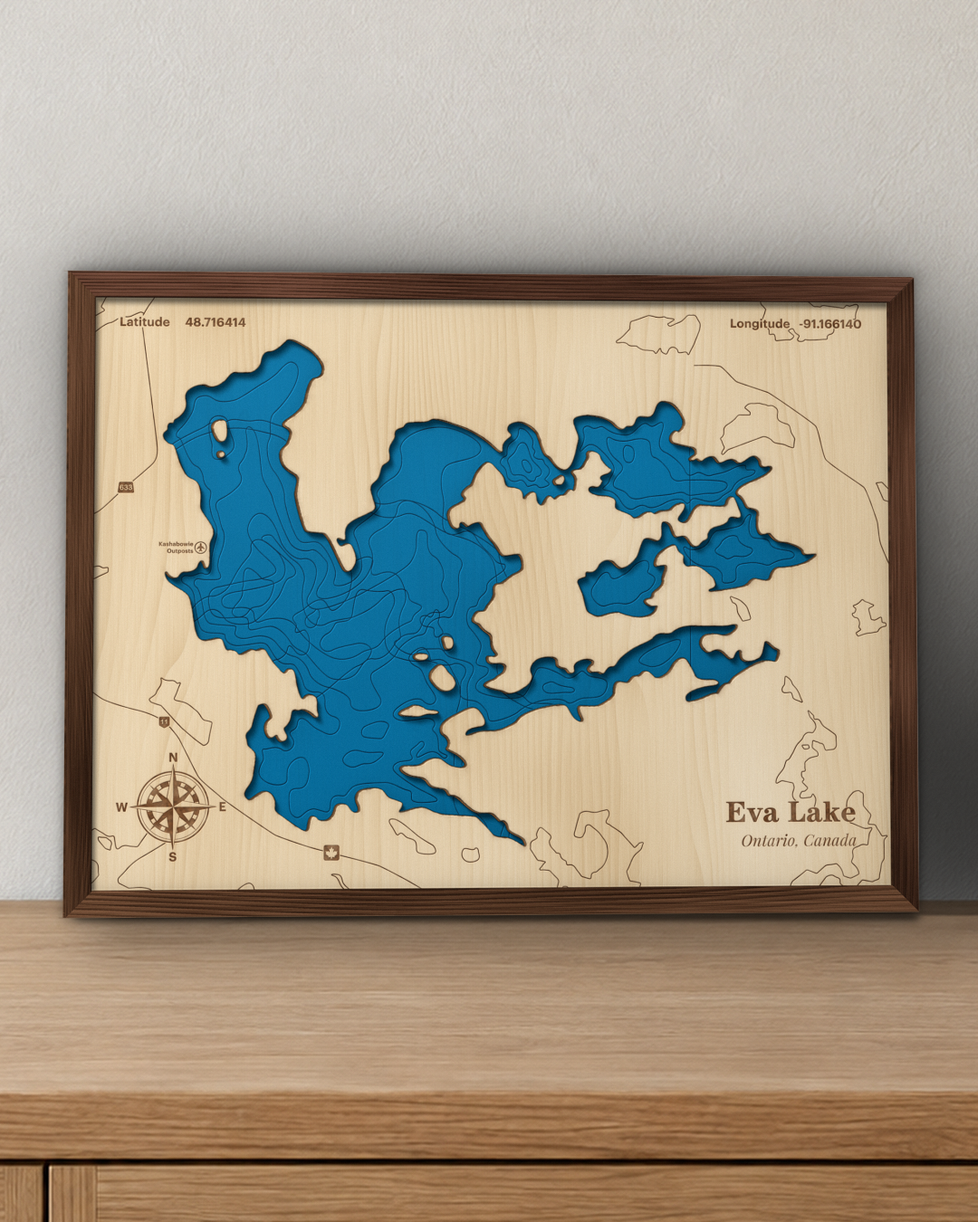 Eva Lake wood map in a walnut frame standing on a wooden sideboard against a wall for scale