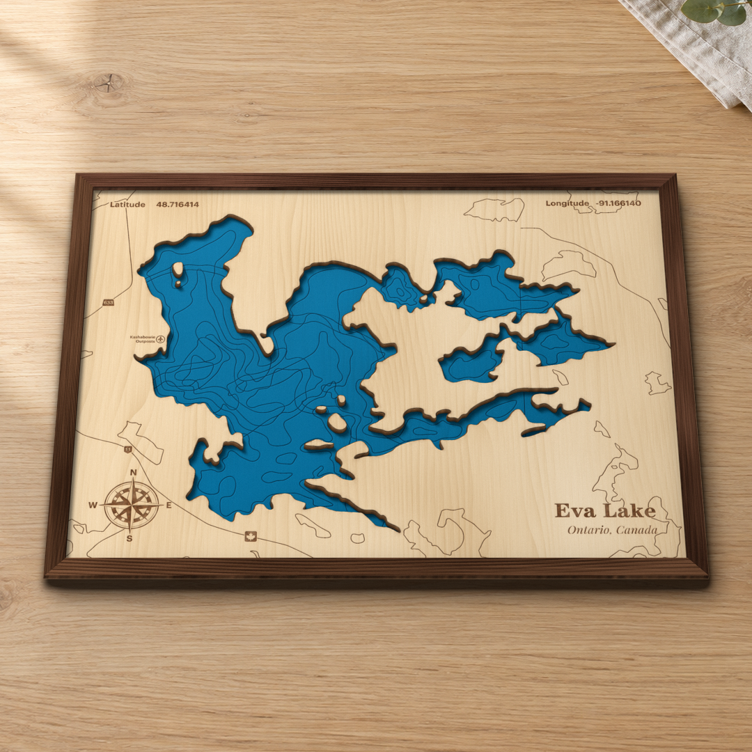 Eva Lake wood map lying flat on a wooden tabletop, showing the depth contours and islands engraved in