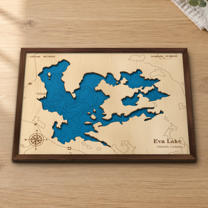 Eva Lake wood map lying flat on a wooden tabletop, showing the depth contours and islands engraved in