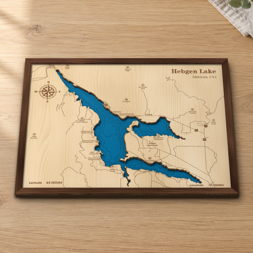 Hebgen Lake wood map lying flat on a wooden tabletop, showing the reservoir's depth contours with the campgrounds, trailheads and Horse Butte engraved in