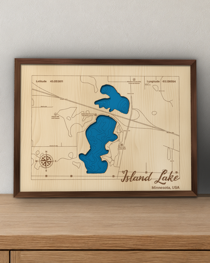 Island Lake wood map in a walnut frame standing on a wooden sideboard against a wall for scale