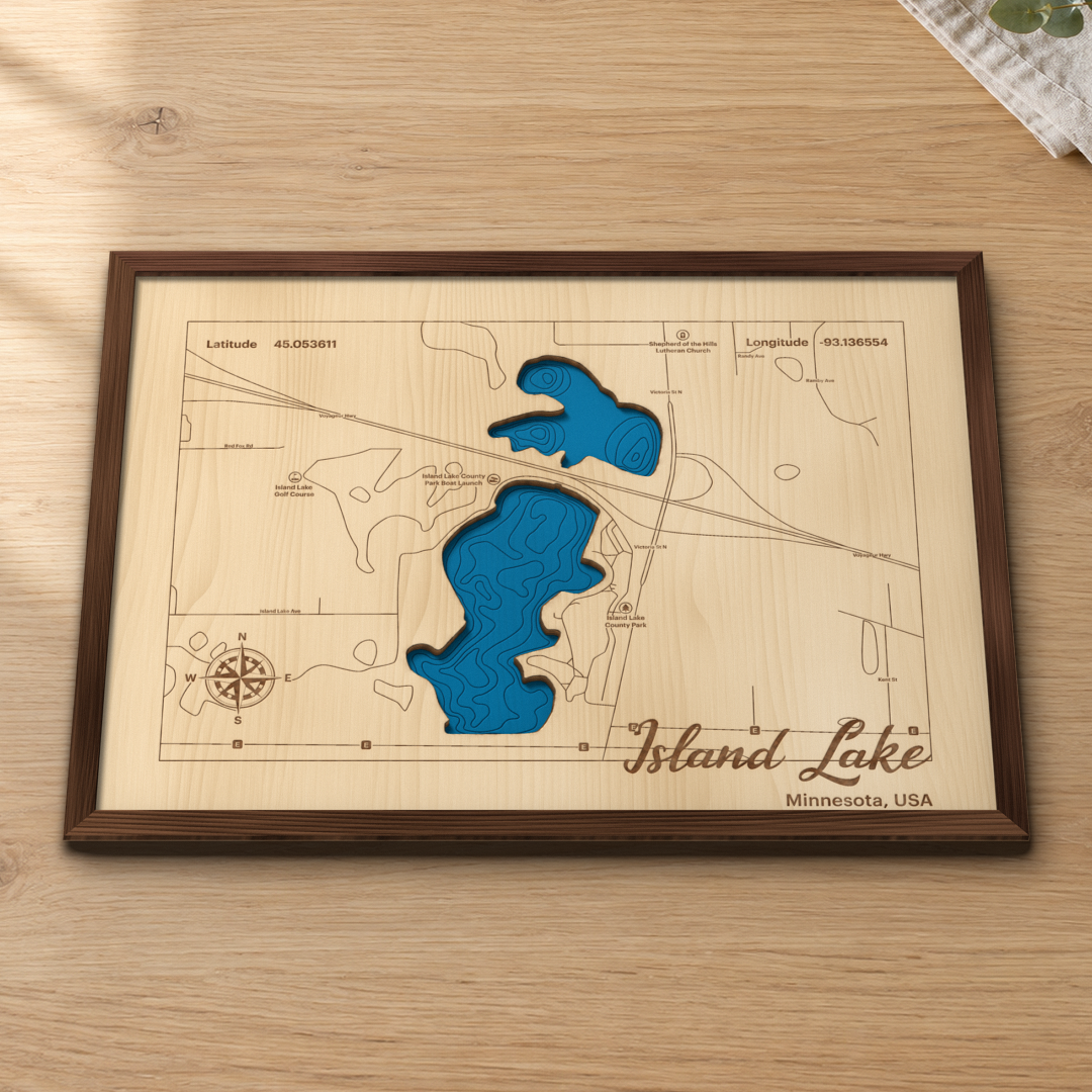 Island Lake wood map lying flat on a wooden tabletop, showing the depth contours and Island Lake County Park engraved in