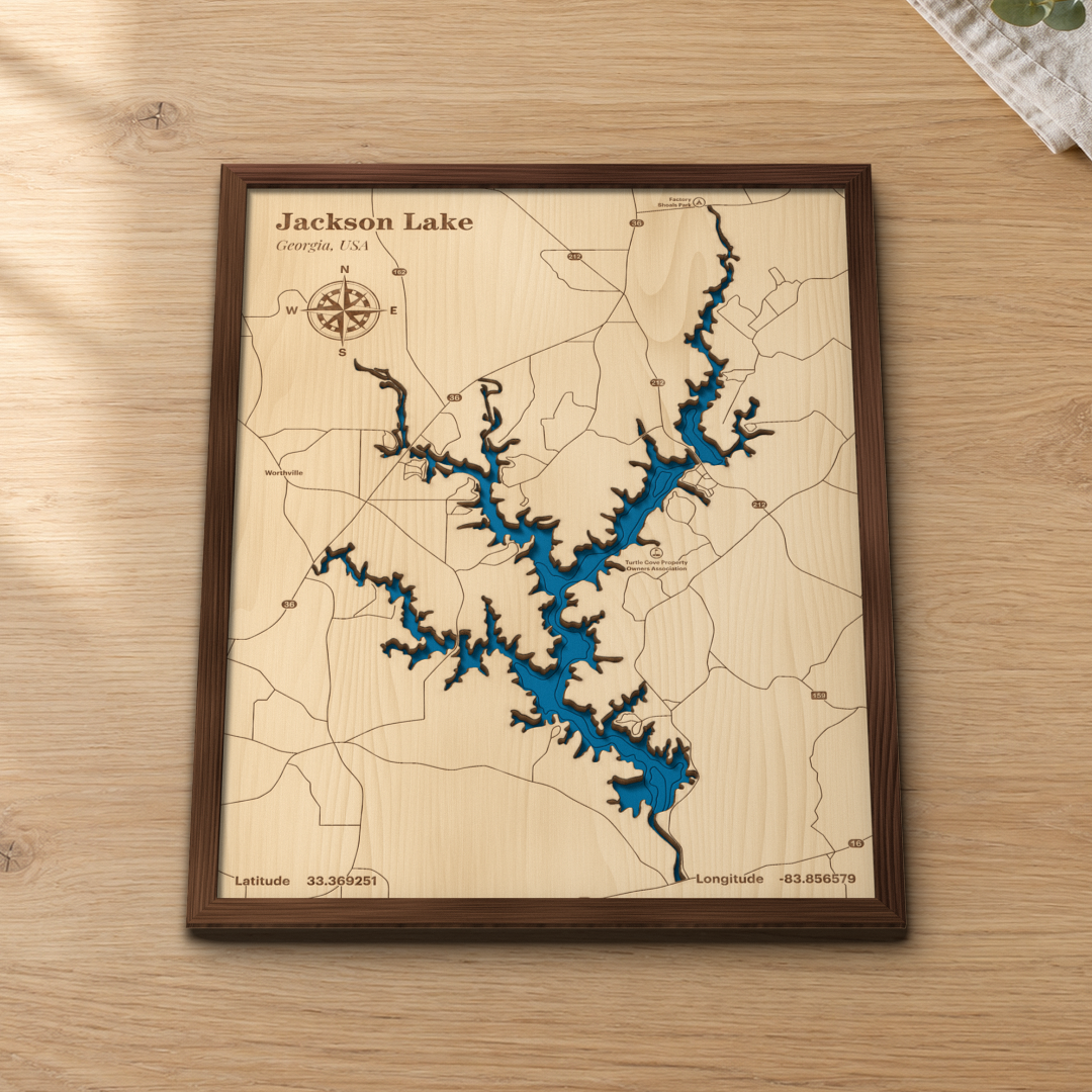 Jackson Lake wood map lying flat on a wooden tabletop, showing the depth contours of its winding arms engraved in