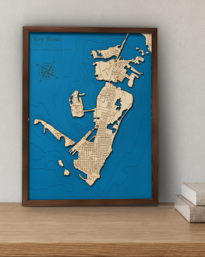 Key West wood map in a walnut frame standing on a wooden sideboard against a wall for scale