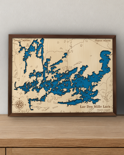 Lac des Mille Lacs wood map in a walnut frame standing on a wooden sideboard against a wall for scale
