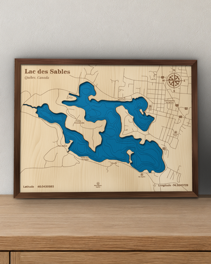 Lac des Sables wood map in a walnut frame standing on a wooden sideboard against a wall for scale