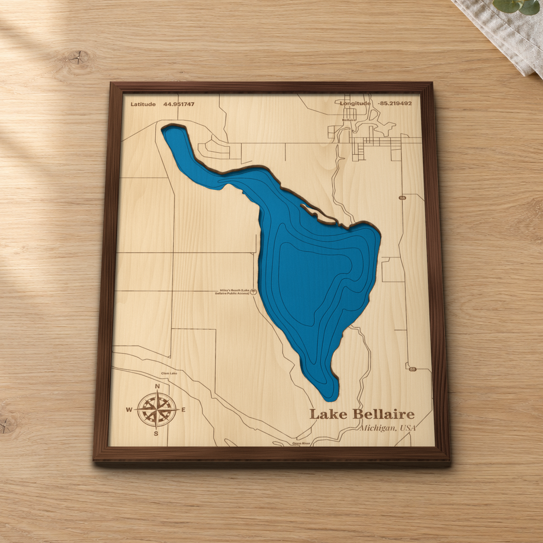 Lake Bellaire wood map lying flat on a wooden tabletop, showing the depth contours engraved in