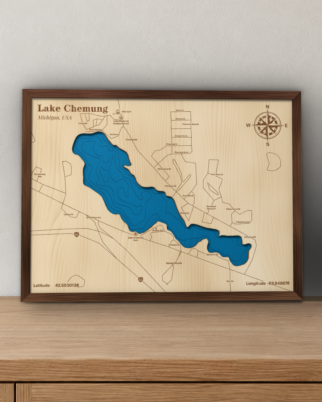 Lake Chemung wood map in a walnut frame standing on a wooden sideboard against a wall for scale