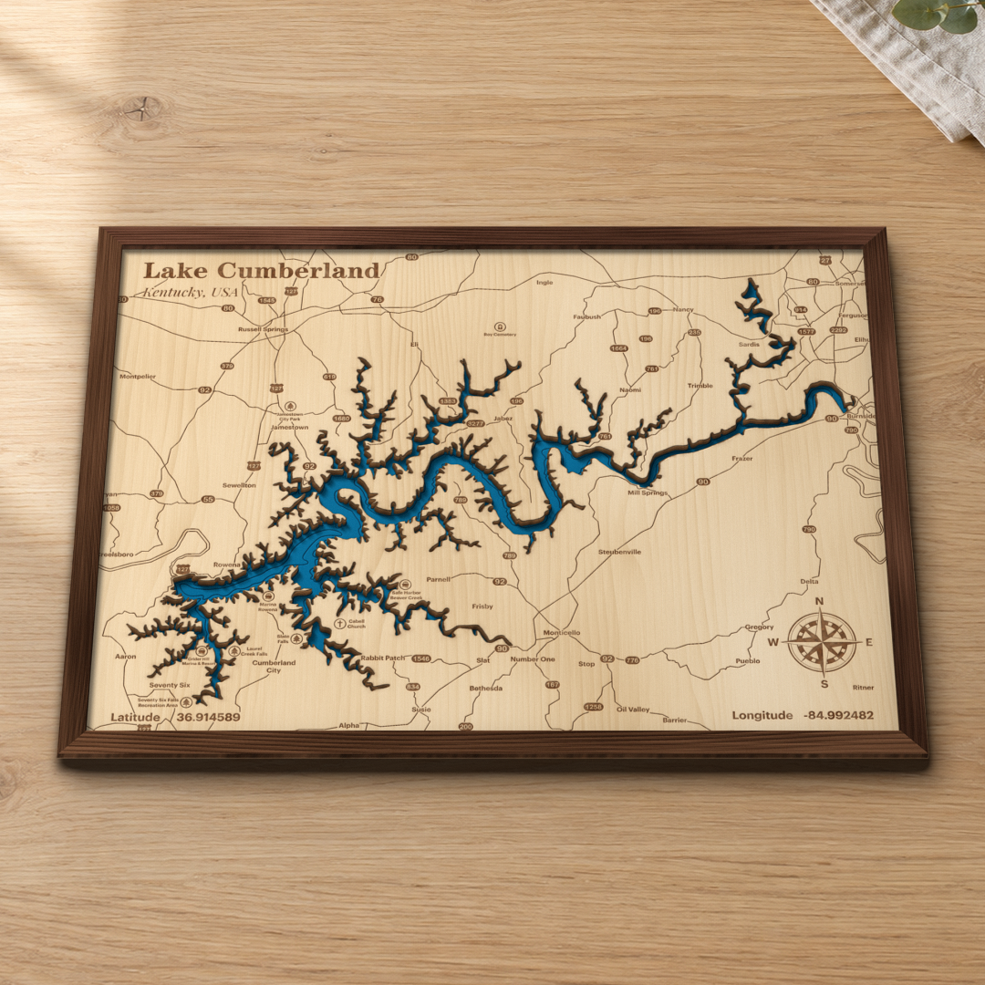 Lake Cumberland wood map lying flat on a wooden tabletop, showing the lake's winding arms and depth contours with Jamestown, Burnside and the marinas engraved in